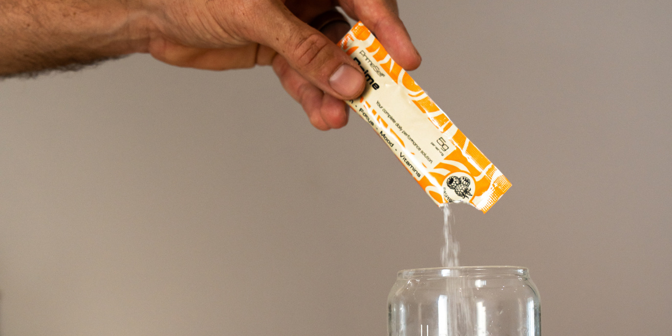 Person mixing Prime Day sachet into water as part of a morning routine